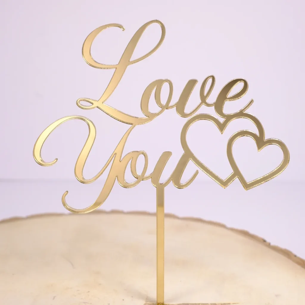 Ein Cake Topper aus goldenem Acryl mit der Aufschrift "Love You" und einem Herz.