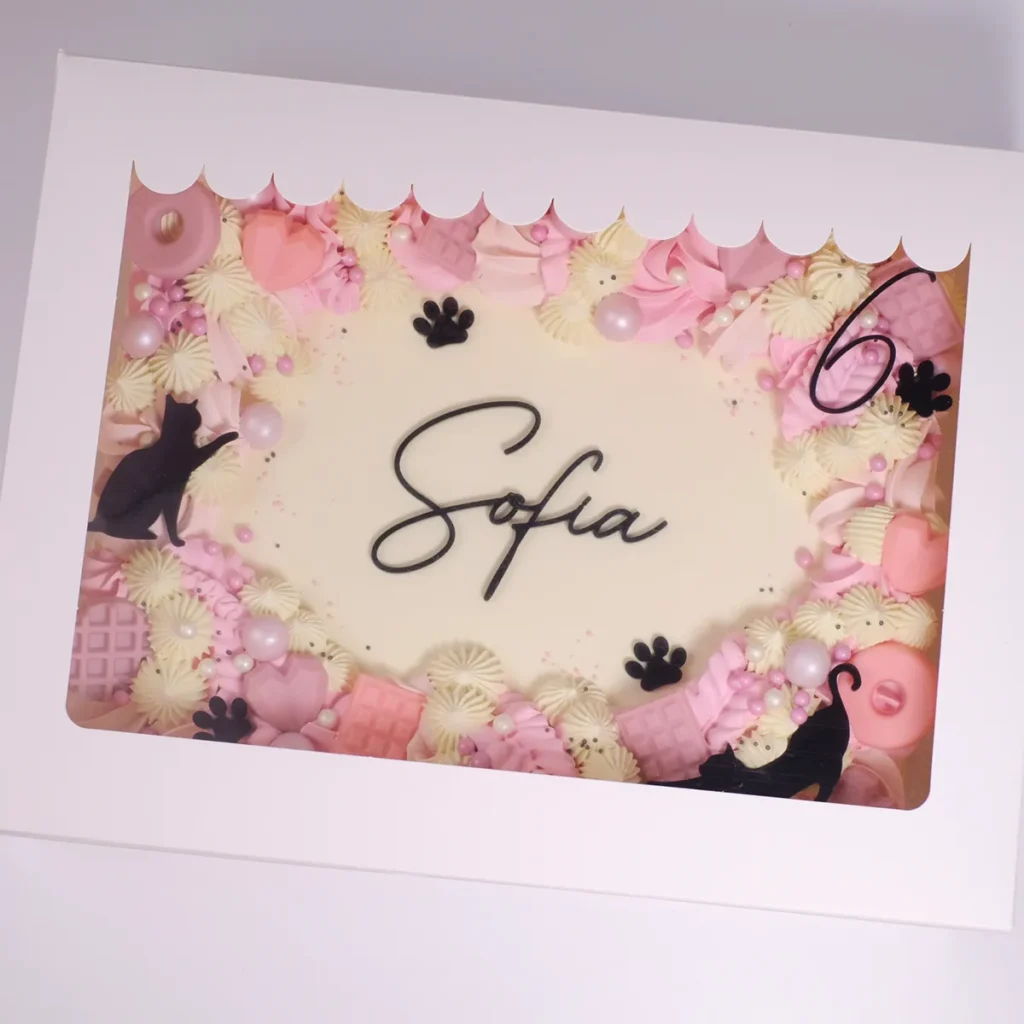 Eine rechteckige Box mit einem Kuchen und Cake Topper "Sofia".